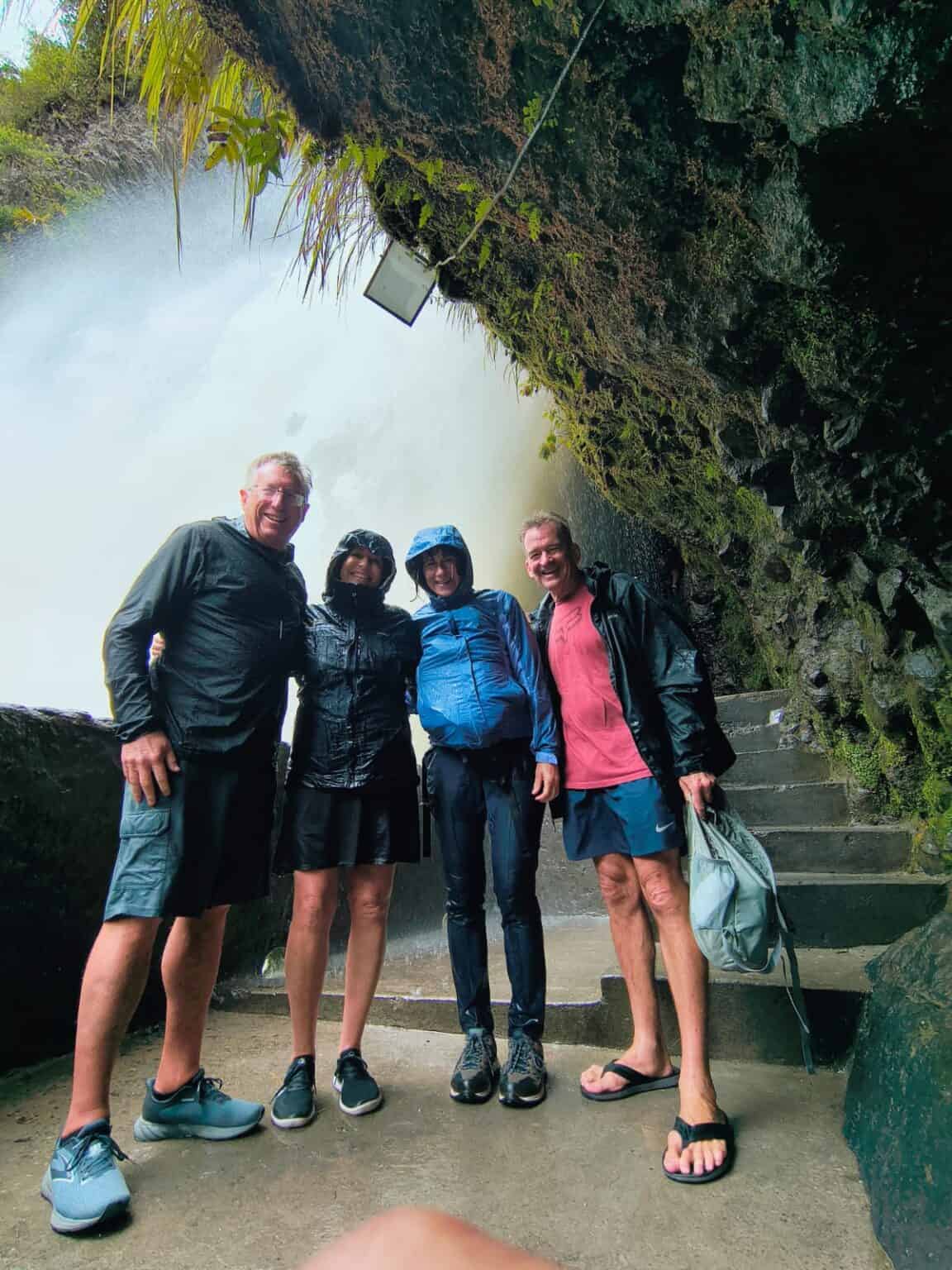 Four friends in rain at waterfall overlook