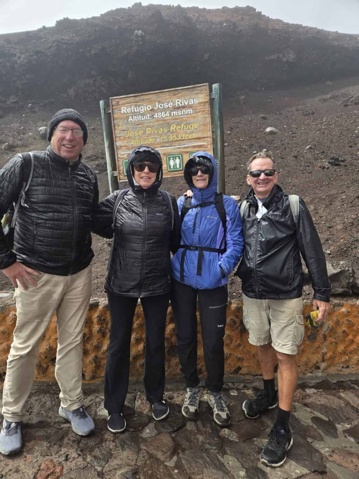 Four hikers at Jose Rivas Refuge sign