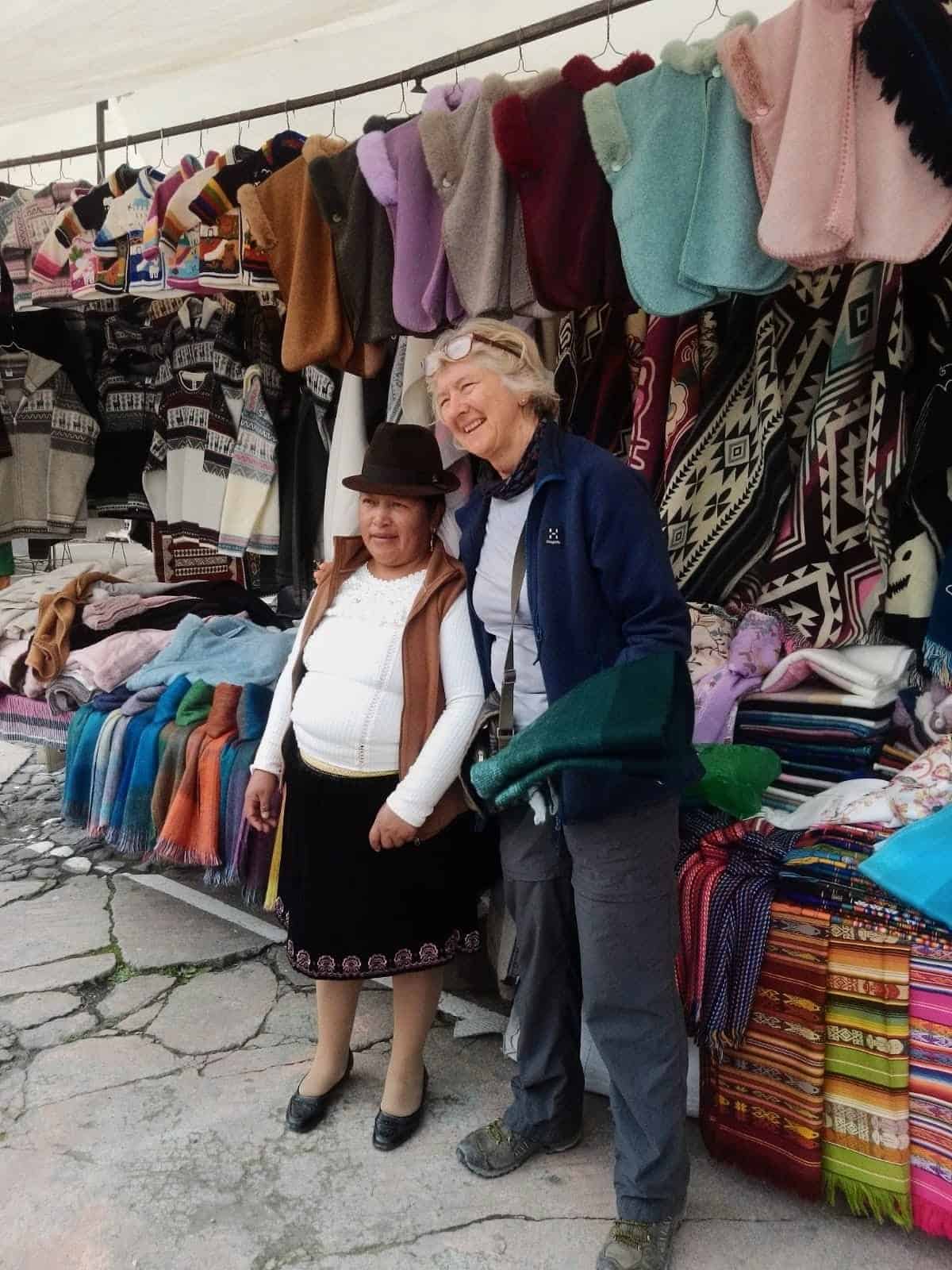 Two women at colorful textile market stall