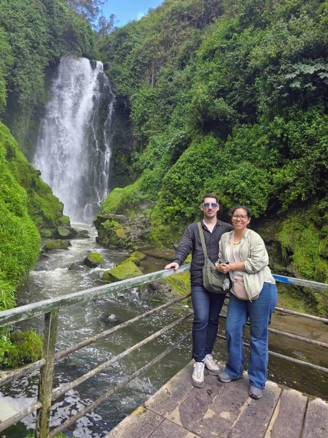 Couple posing by lush waterfall and river