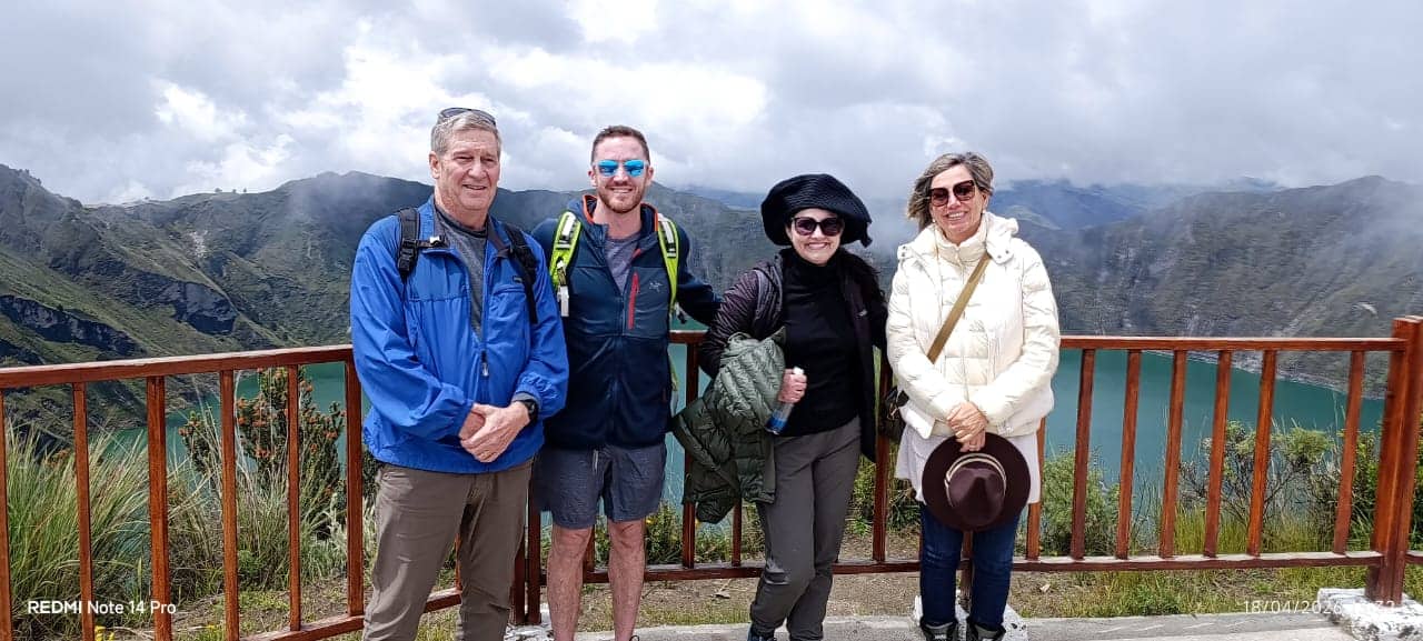 Four hikers at mountain lake viewpoint