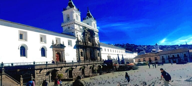 Historic white cathedral overlooking bustling city plaza