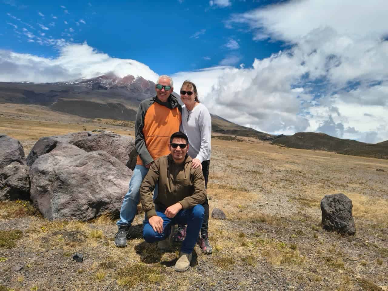 Group posing in mountains under blue sky