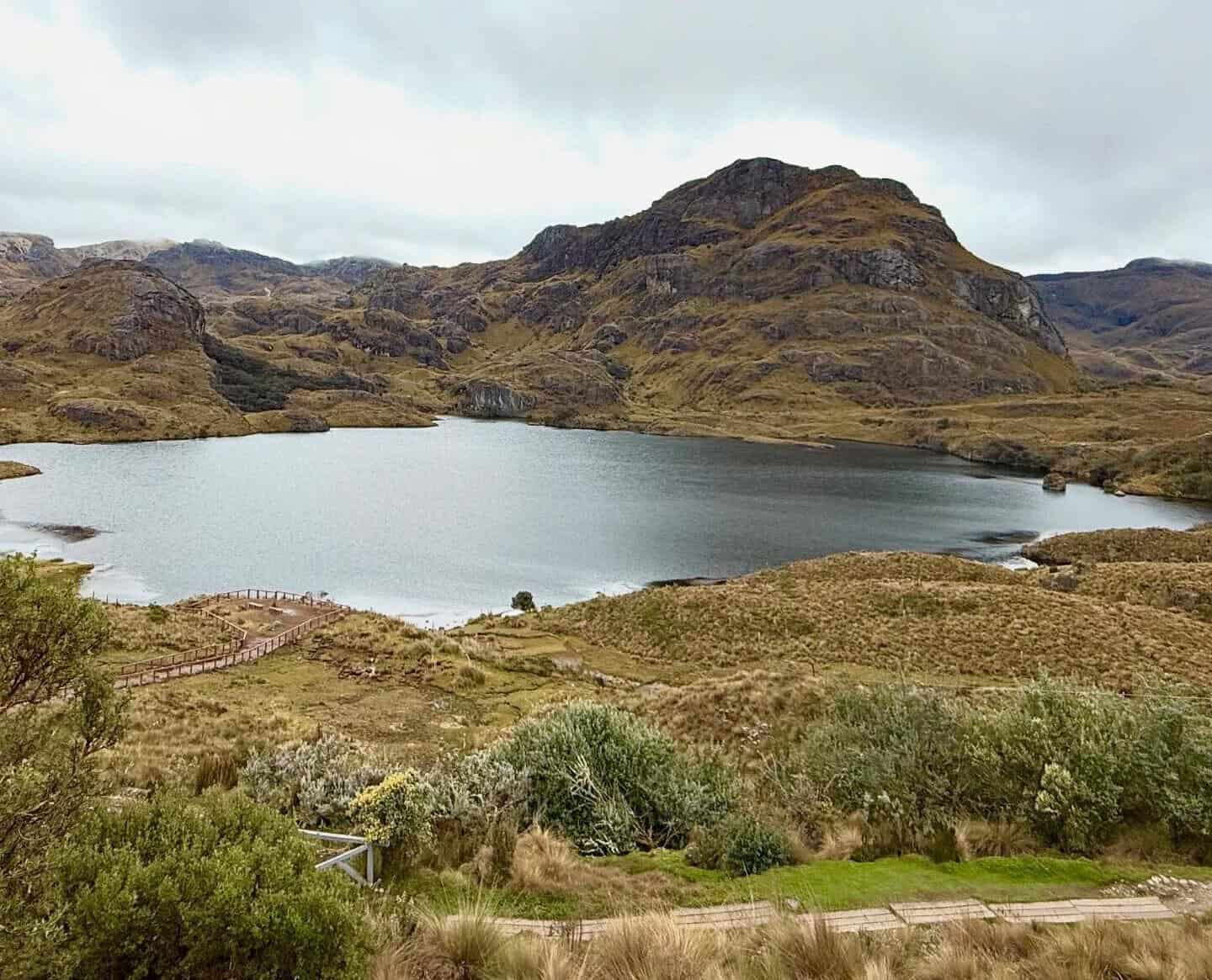 Mountain lake surrounded by rocky hills and grassland