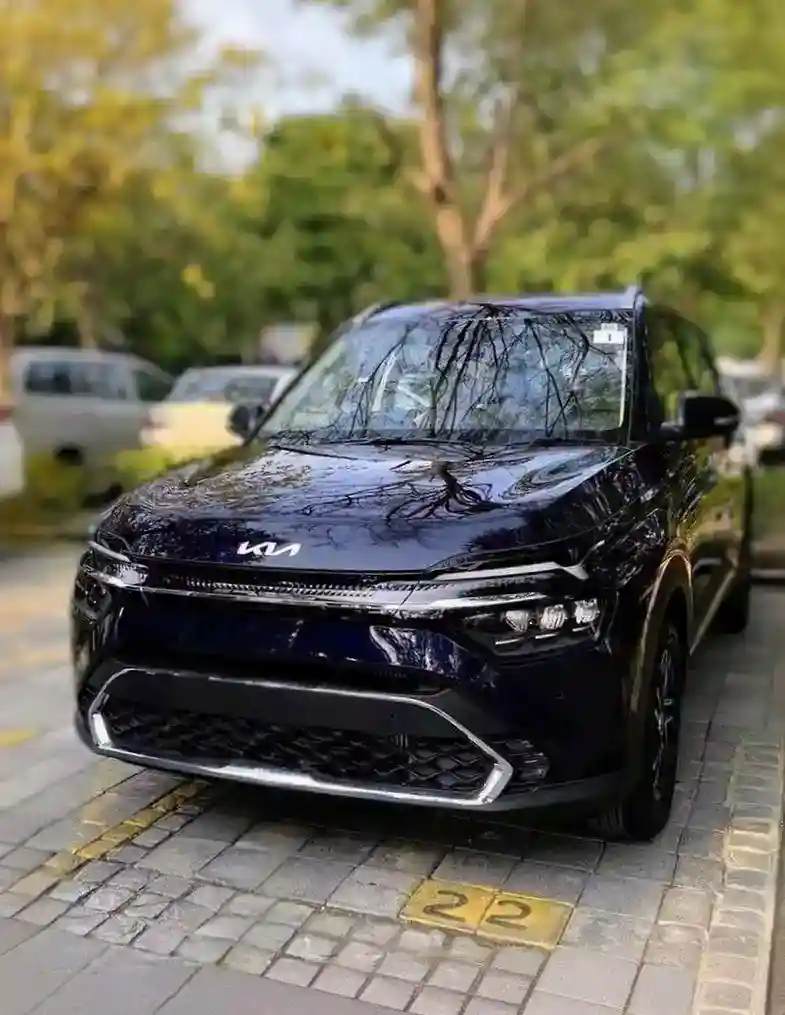 Black Kia SUV parked on tree-lined street
