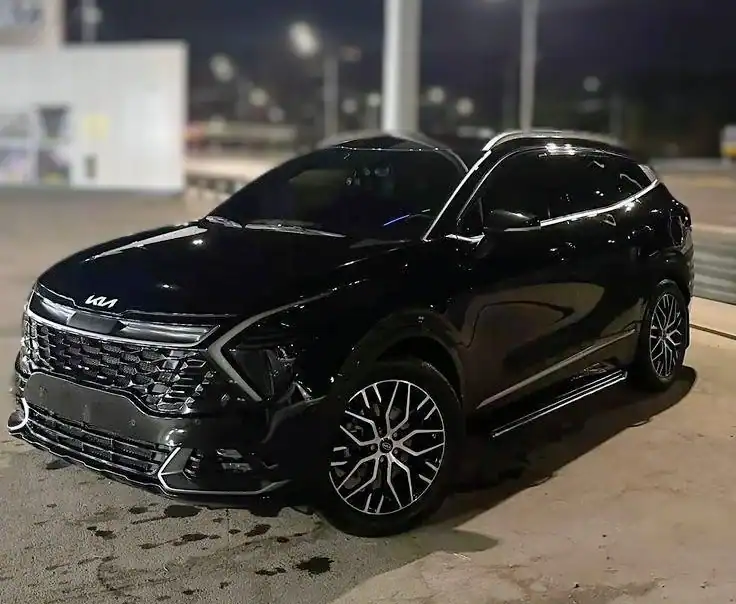 SUV Kia negro aparcado de noche
