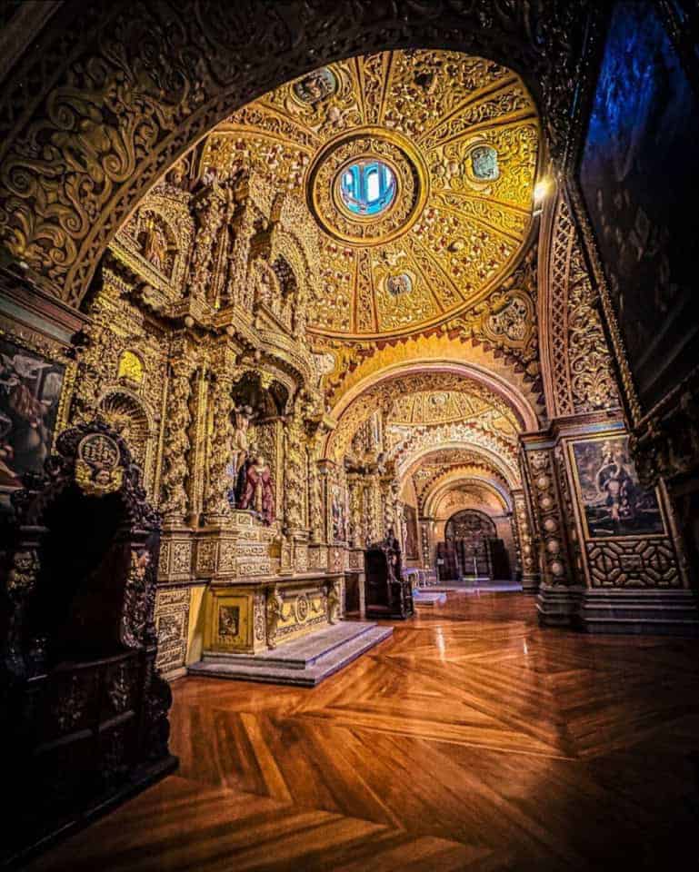 Ornate gilded chapel interior with vaulted ceiling and polished floor
